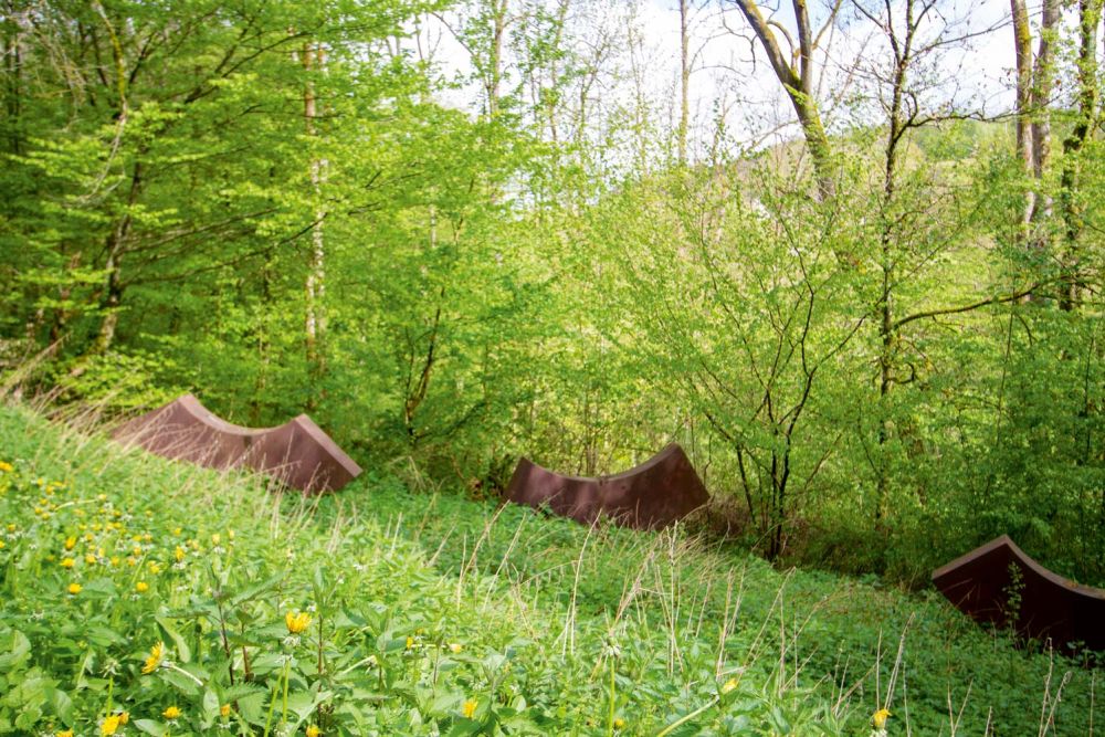 Skulpturen auf einer Wiese im Wald