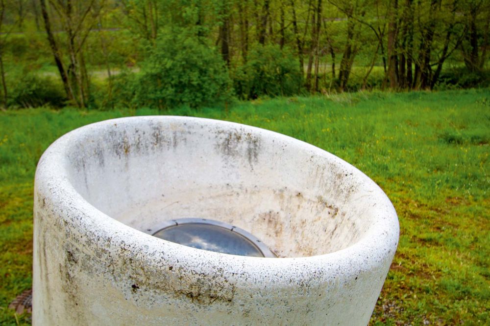 Weiße Runde Skulptur mit einem Bullauge in der Mitte