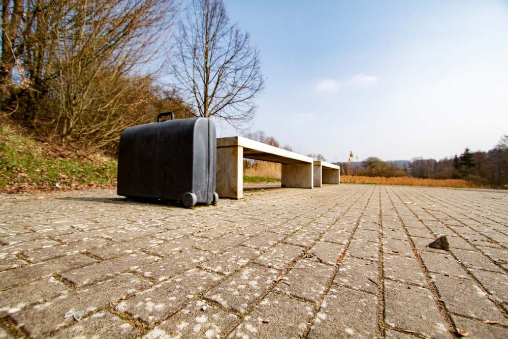 Zwei Bänke und ein schwarzer Koffer